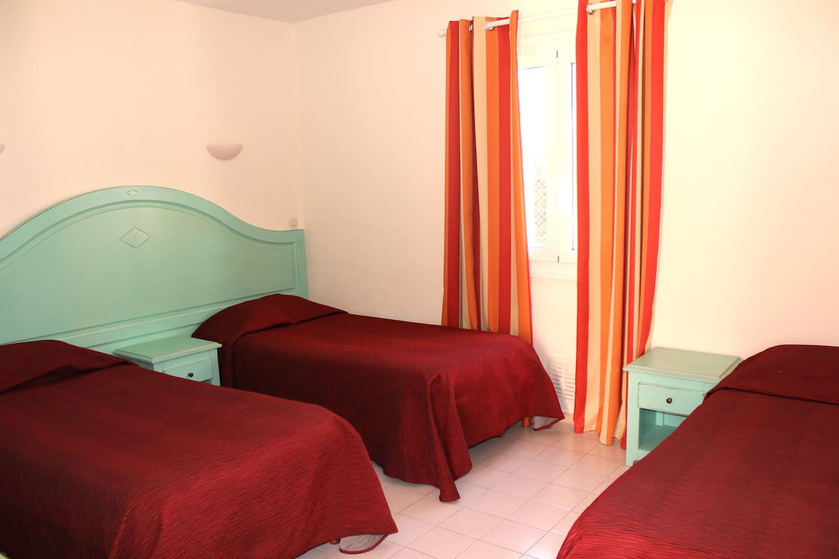 A room with two beds, each with a matching headboard and footboard, and a single bedside table.