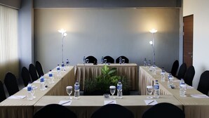 A conference room with a long table, chairs, water bottles, and glasses. - Indoluxe Rent Apartment Jogja (Depok)