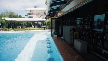 Una piscina con un área de bar contigua.