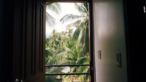 Un acceso que da a un jardín tropical exuberante con follaje denso y palmeras.