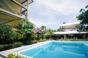 Una piscina al aire libre, sillones reclinables de piscina