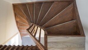 Una escalera de caracol con peldaños de madera y barandillas de metal.