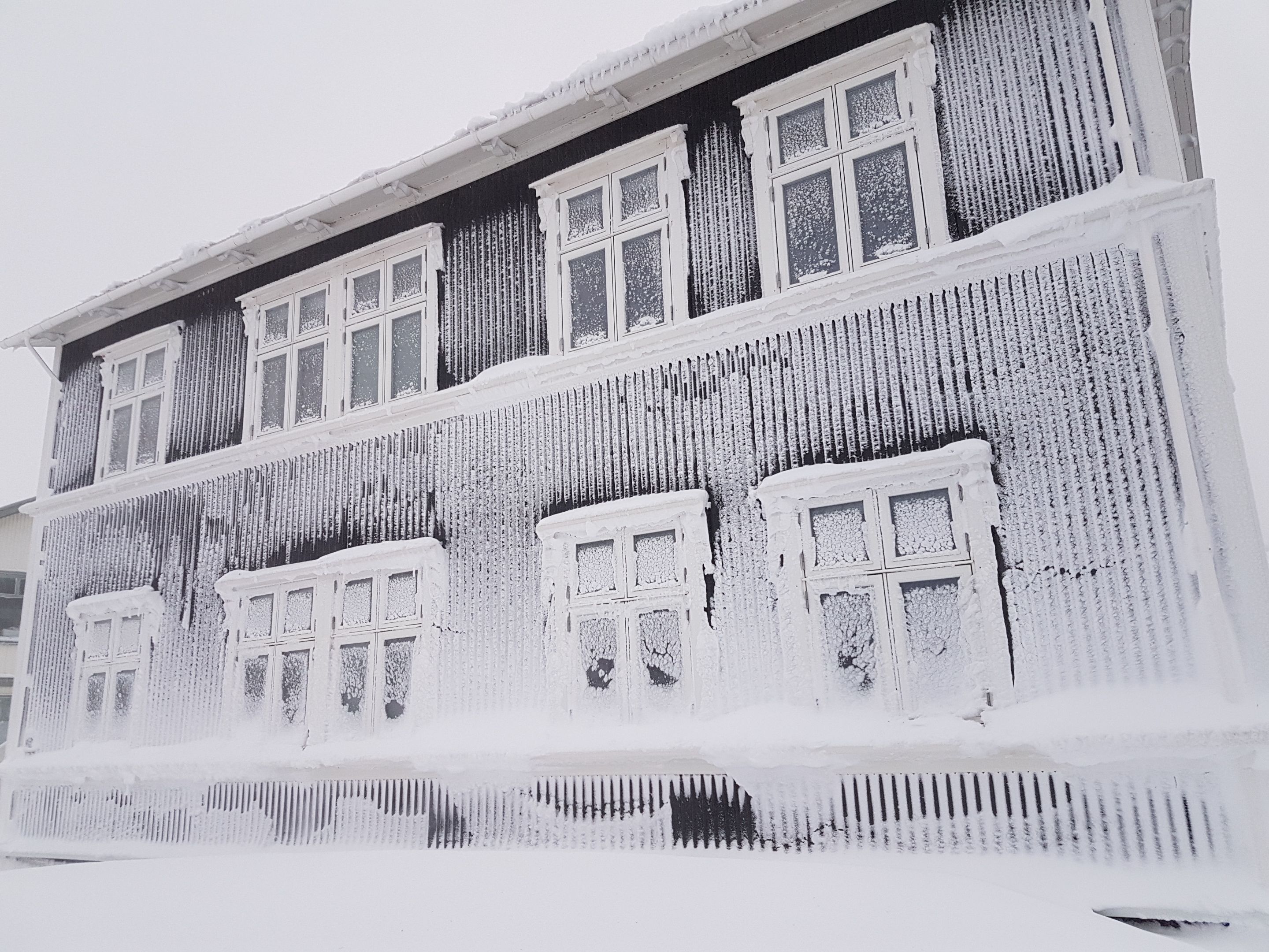 Un edificio con diverse finestre, alcune delle quali sono ricoperte di neve.