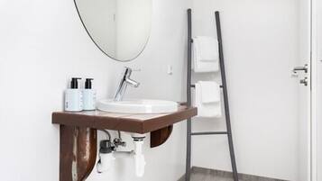 A bathroom with a white sink, a mirror, and a towel rack.