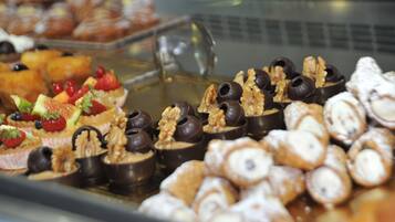 A variety of pastries and desserts displayed in a glass case.
