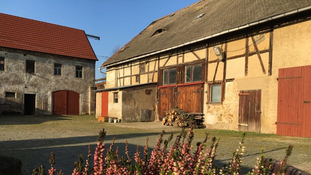 A traditional half-timbered building with a red roof and wooden doors.