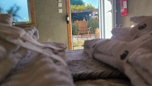 Un dormitorio con vista a un jardín a través de un ventanal.