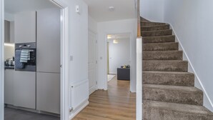 Eine moderne Küche mit weißen Schränken, einem eingebauten Backofen und einer Arbeitsplatte mit einem Wasserkocher.
