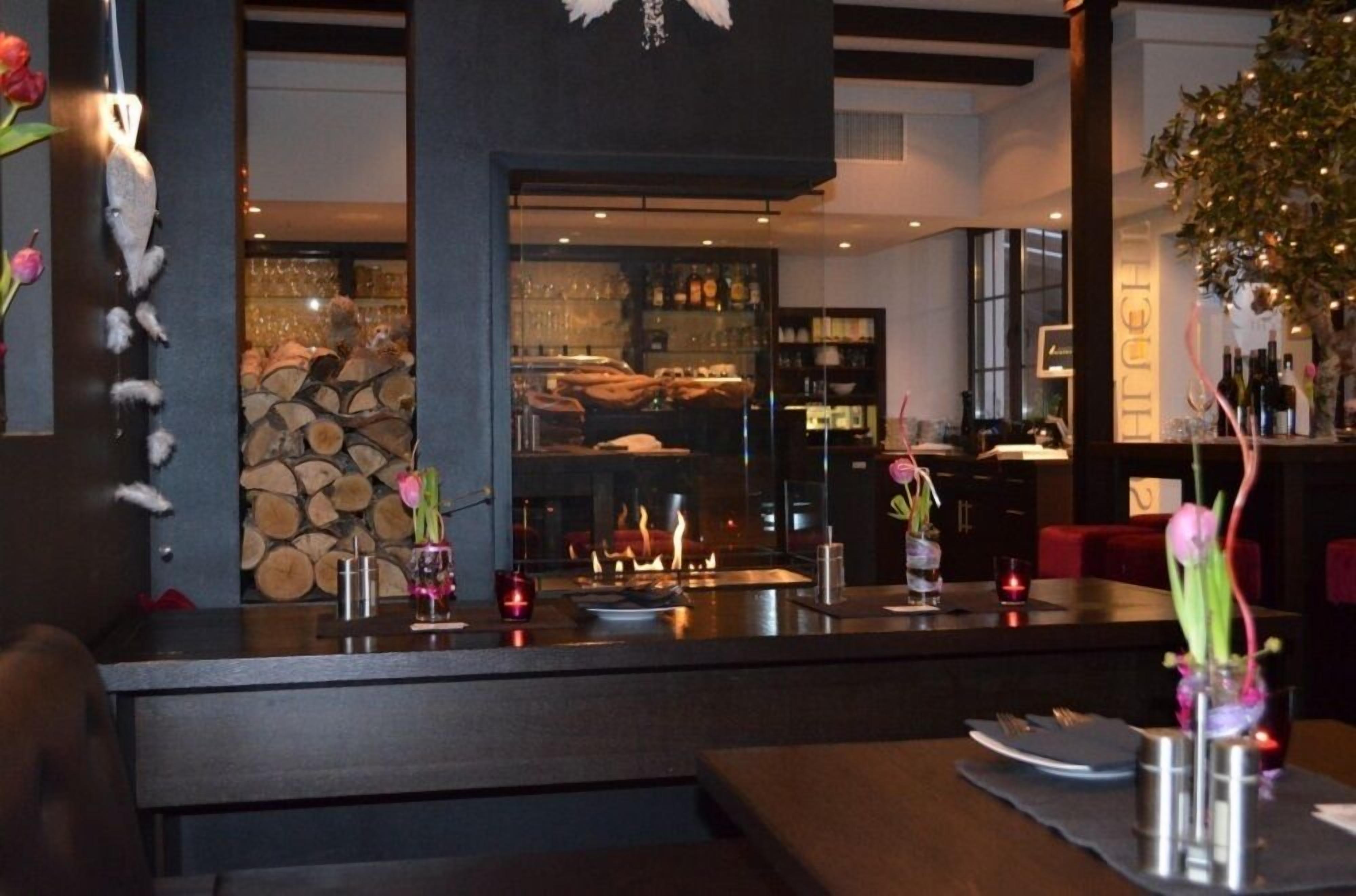 Un restaurant doté d’un bar, d’une cheminée et offrant une vue sur le paysage urbain.