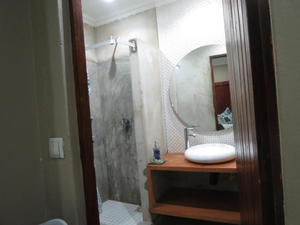 Un baño con ducha, lavabo y espejo.