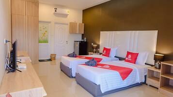 Quarto de hotel com duas camas, uma escrivaninha, televisão, frigorífico e ar condicionado fixado na parede.