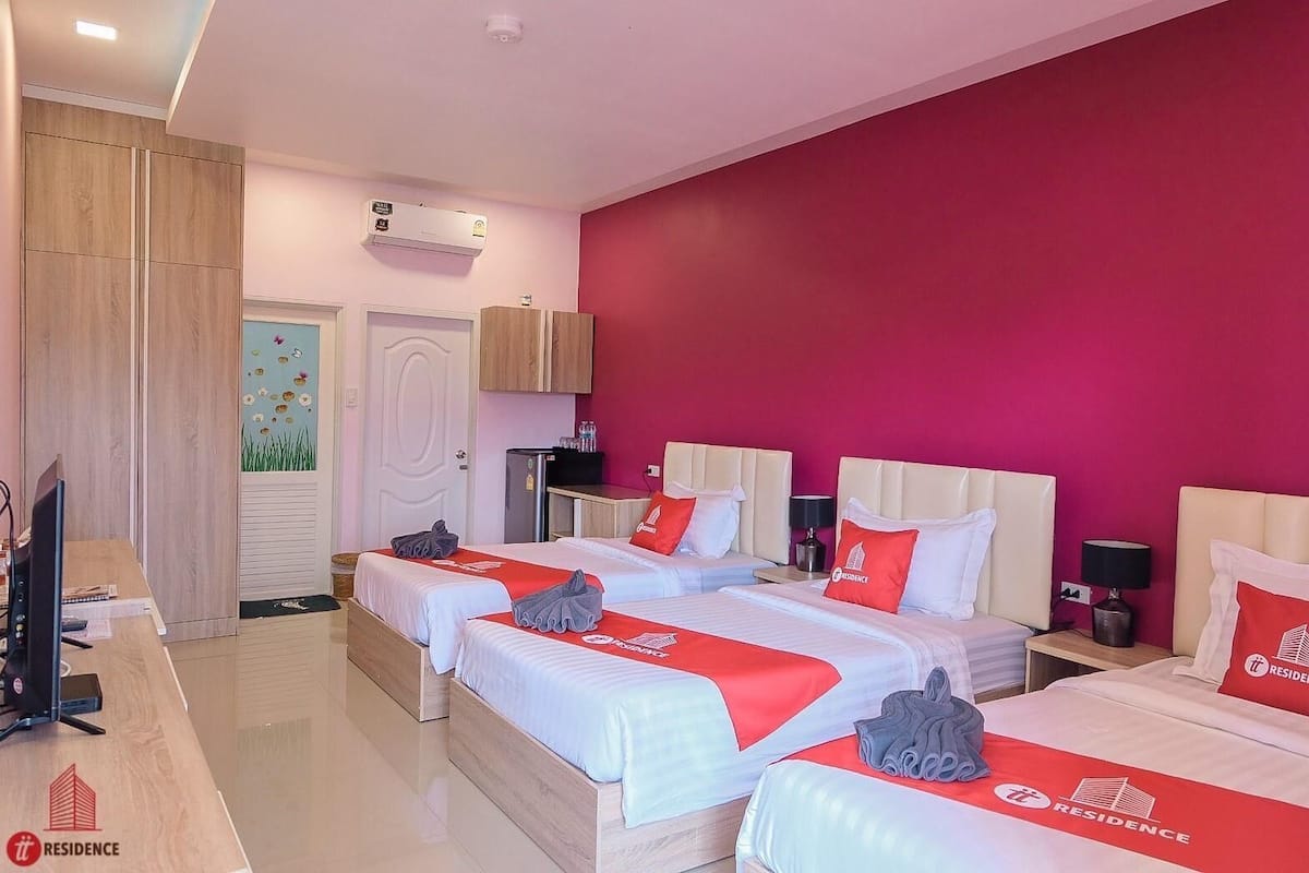Une chambre d’hôtel avec deux lits, un bureau, une télévision et une armoire.