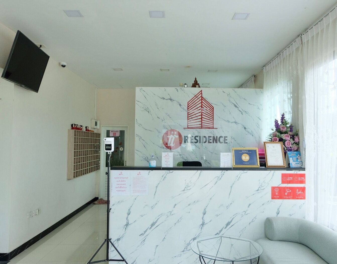 A reception area with a marble counter, a framed logo, and a small plant.