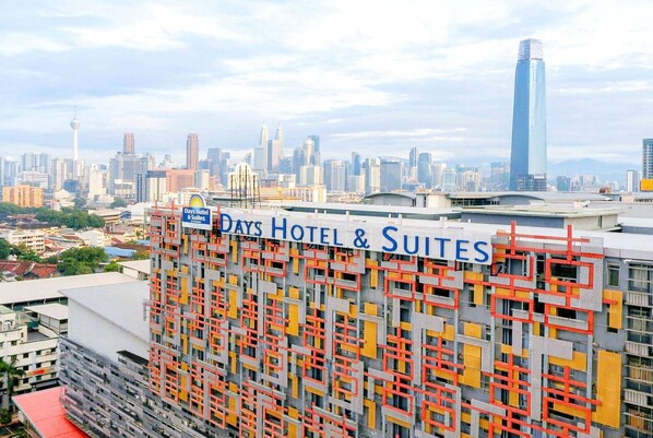 A hotel with a sign reading "Days Hotel & Suites" and a view of a city skyline in the background. - Days Hotel and Suites Fraser Business Park KL (Kuala Lumpur)