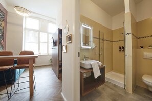 Une salle de bain moderne équipée d’une douche, de toilettes et d’un meuble-lavabo.