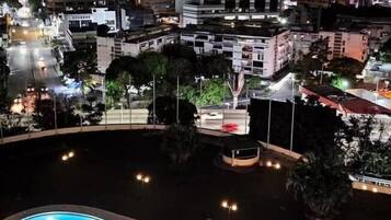 Relax by the illuminated pool surrounded by the city's vibrant architecture.