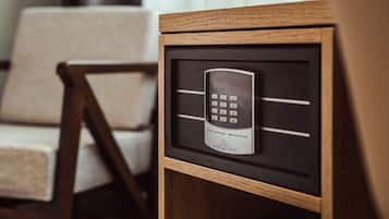 A framed electronic device on a wooden surface, possibly a control panel or remote, with a chair in the background.