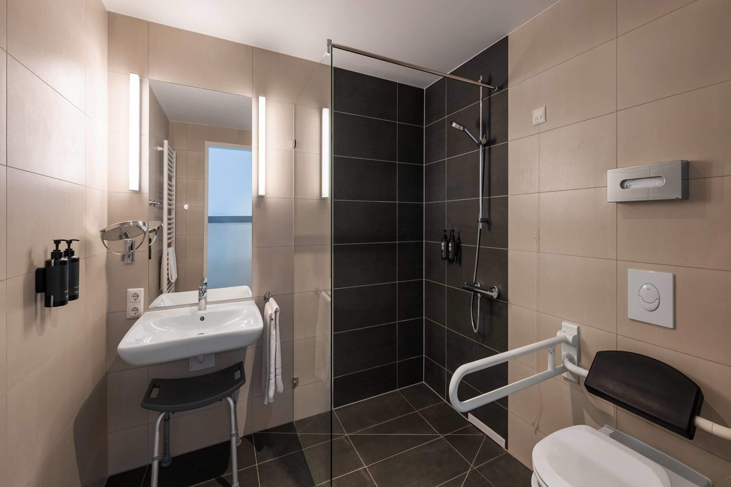 A modern bathroom with a shower, toilet, and sink.