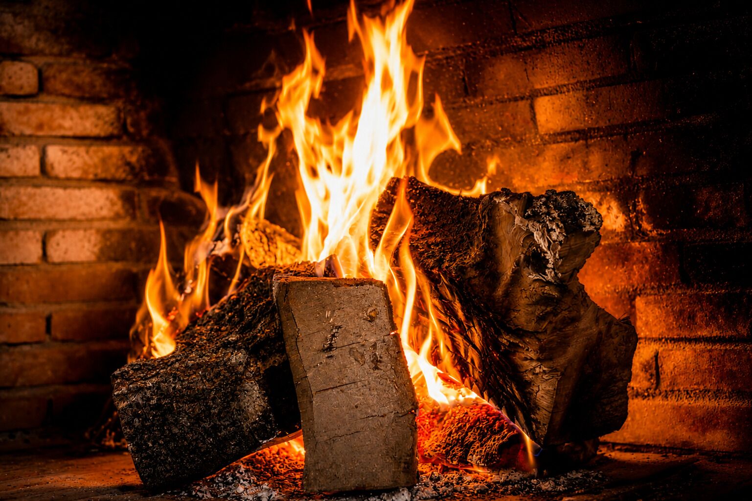 A fireplace with burning logs and flames.