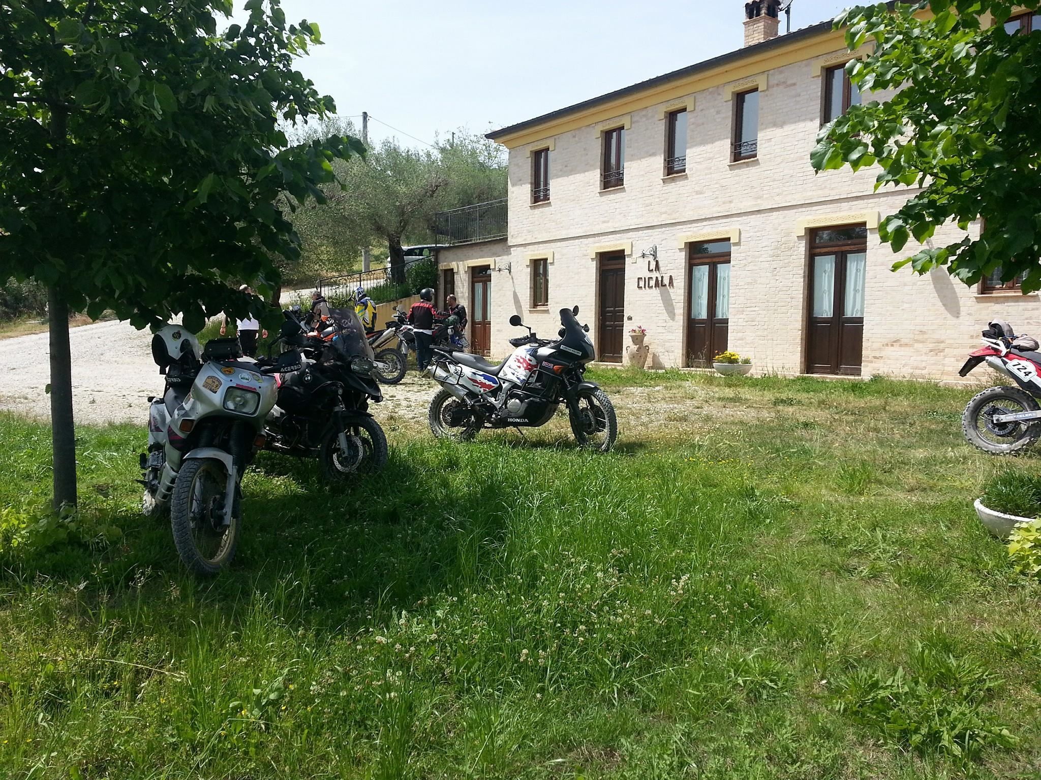 Un edificio con fachada de ladrillo y varias ventanas, rodeado de motocicletas estacionadas.
