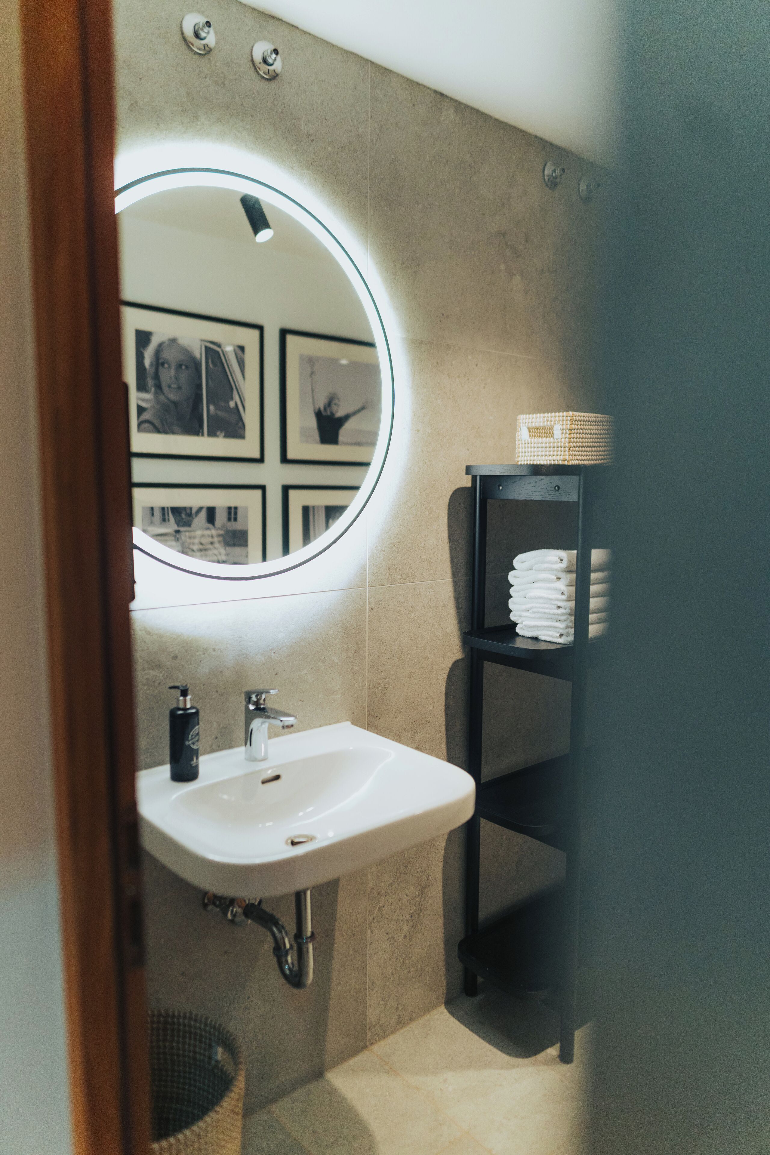 Ein Badezimmer mit einem weißen Waschbecken, einem Spiegel und einem Handtuchhalter.