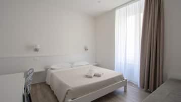 Quarto moderno e limpo, com uma cama de solteiro, mesa de cabeceira e uma janela grande com cortinas.