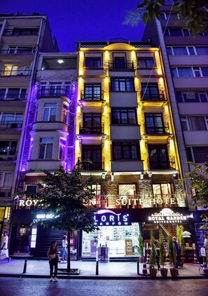 A multi-story hotel with illuminated balconies and signage for the Royal Garden Suite Hotel.