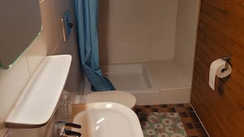 Ein Badezimmer mit Waschbecken, Toilette, Dusche und einer kleinen Fußmatte.