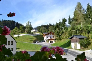 A residential area with houses, a road, and a hilly landscape.