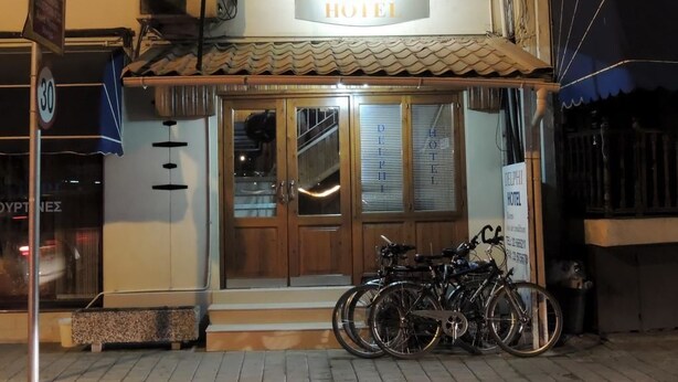 A hotel named DELPHI HOTEL with a tiled roof, wooden doors, and a signboard. There are bicycles parked in front. - Delphi Hotel (Nicosia)