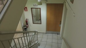 A staircase with a handrail, a fire extinguisher, and a 'No Smoking' sign on the wall. - Delphi Hotel (Nicosia)