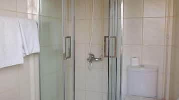 Chuveiro, toalhas de banho, sabonete, shampoo