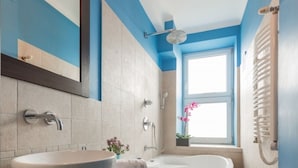 A modern bathroom with a large vessel sink, a freestanding bathtub, and a window providing natural light. - P&O Chimielna 3 (Warsaw)