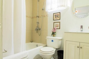 A bathroom with a bathtub, toilet, and shower. - Strathairn 110 by Pro Homes Jamaica (Kingston)