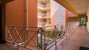 A corridor with a metal railing, leading to a multi-story building with balconies. - Strathairn 110 by Pro Homes Jamaica (Kingston)