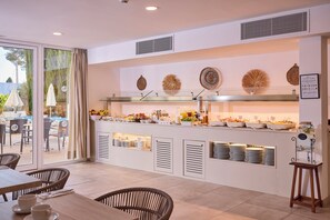 A breakfast bar with a variety of food items and a glass display case. - INNER Hotel Rupit - Adults Only (Santanyi)