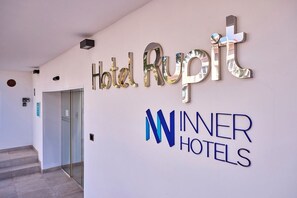 A hotel entrance with a sign for 'Hotel Rupit' and 'Winner Hotels' logo. - INNER Hotel Rupit - Adults Only (Santanyi)