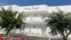 A hotel named "Hotel Rupt" with a white facade, balconies, and surrounding greenery. - INNER Hotel Rupit - Adults Only (Santanyi)