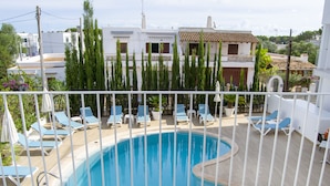 A swimming pool with lounge chairs and a white fence. - INNER Hotel Rupit - Adults Only (Santanyi)