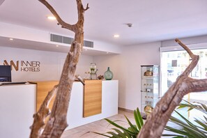 A reception desk with a wooden panel, a glass display case with items, and a sign reading 'WINNER HOTELS'. - INNER Hotel Rupit - Adults Only (Santanyi)