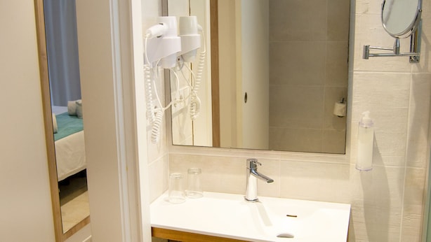A bathroom with a white sink, mirror, and towel rack. - INNER Hotel Rupit - Adults Only (Santanyi)