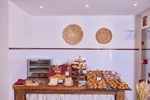 Mostrador de panadería con diversas opciones de productos horneados y un horno de pan.