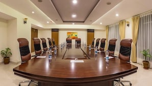 A conference room with a long table, multiple chairs, and a painting on the wall. - OYO Premium Secunderabad Station (Hyderabad)
