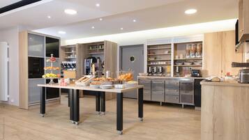 A modern kitchen with a central island, built-in appliances, and open shelving.