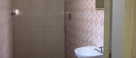 A small bathroom with a toilet, a sink, and a shower.