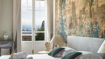 Une chambre d’hôtel avec un grand lit, une vue sur la ville et une tapisserie au mur.