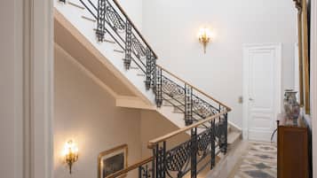 A grand staircase with ornate black railings and a white door at the top.
