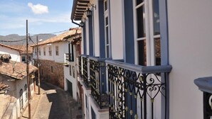 A narrow street with buildings featuring balconies and traditional architecture.