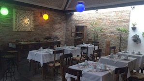 A restaurant with stone walls, wooden tables, and chairs.
