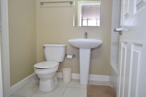 A small bathroom with a toilet, sink, and a mirror above the sink.